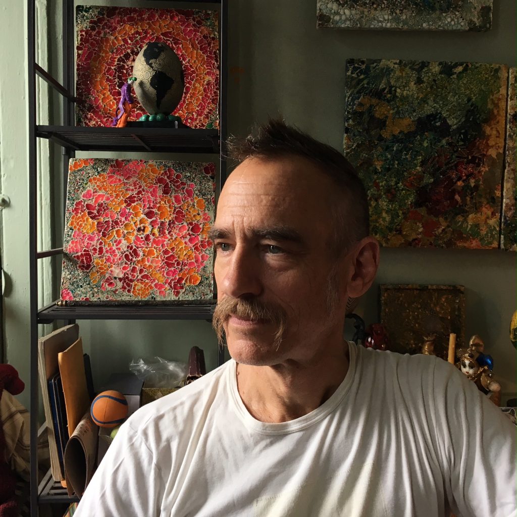 photo of Rosie Delicious, aka Paul Wirhun, in his studio with art